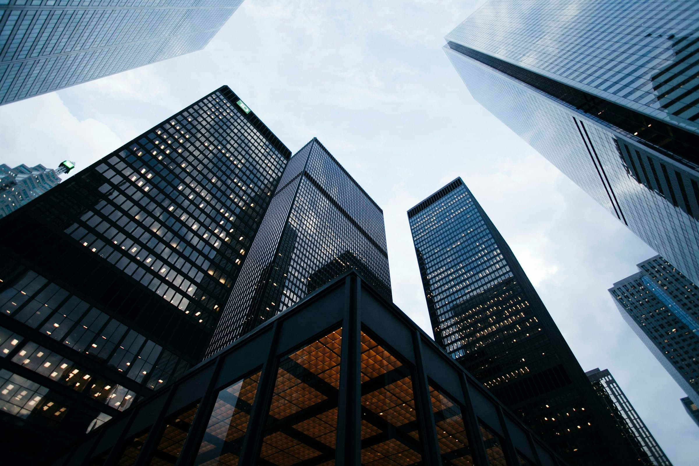Glass towers photographed from below against an overcast sky