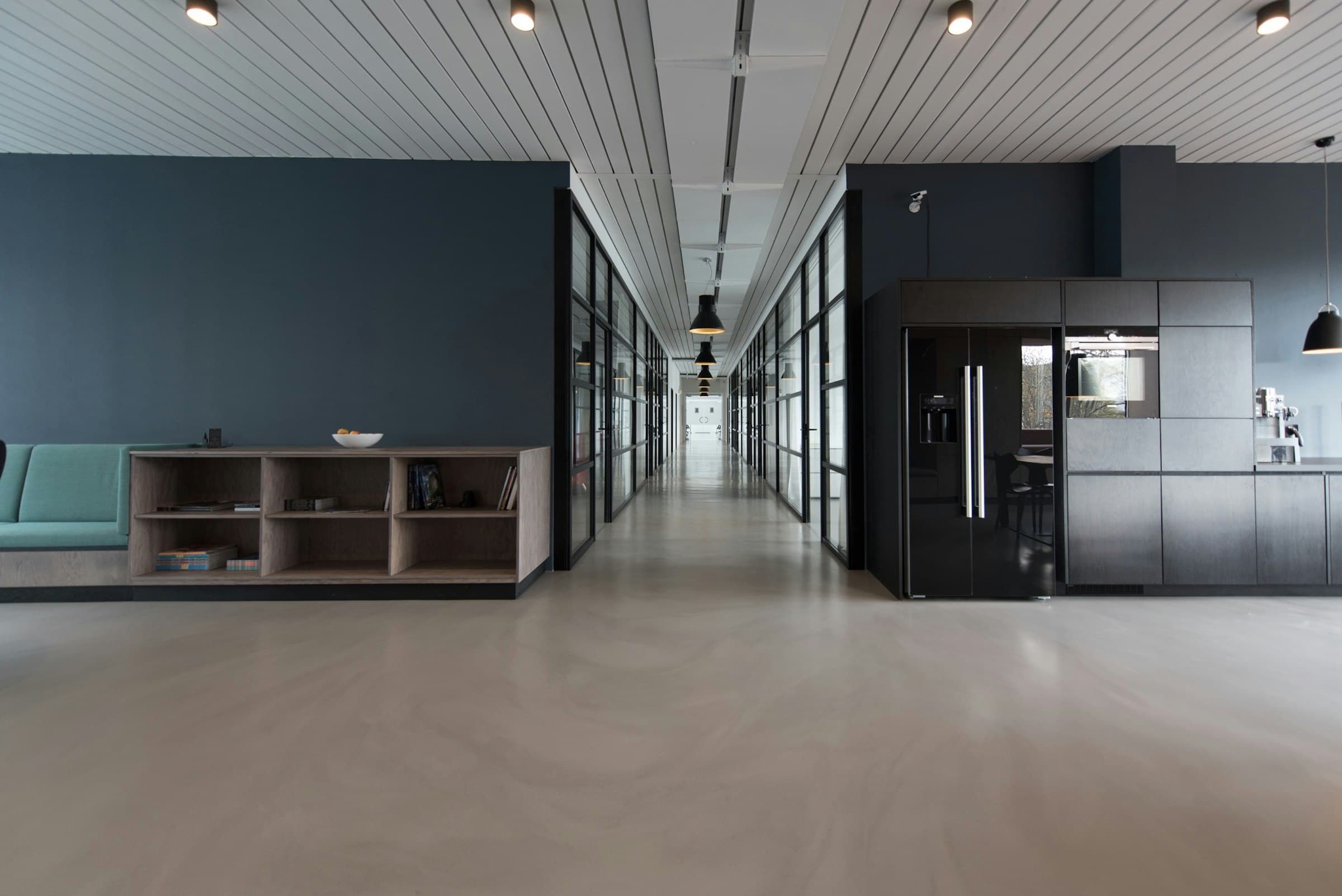 A calm, minimal office interior with dark walls and clean lines