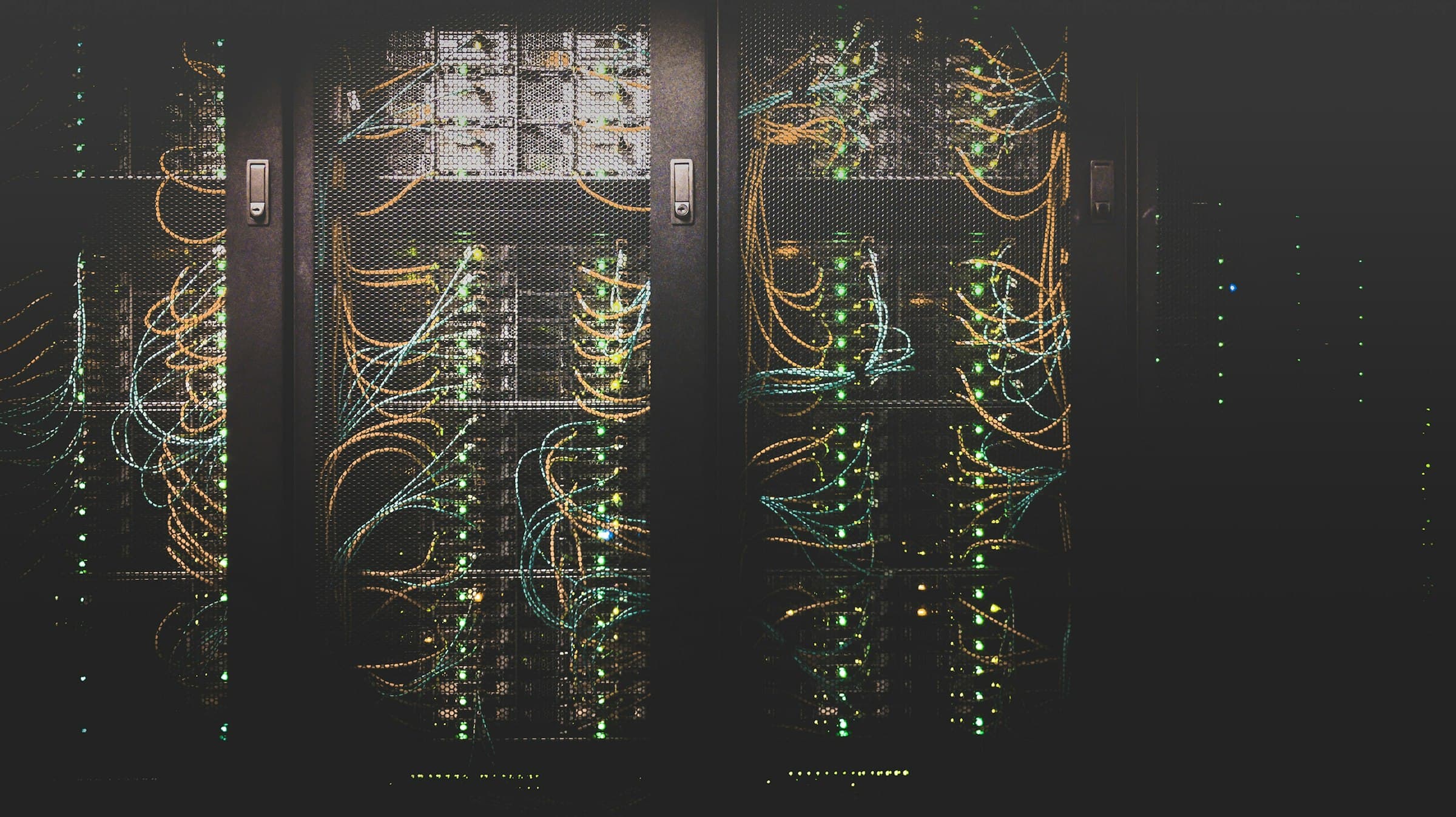 Racks de servidores oscuros con cableado tras puertas de malla